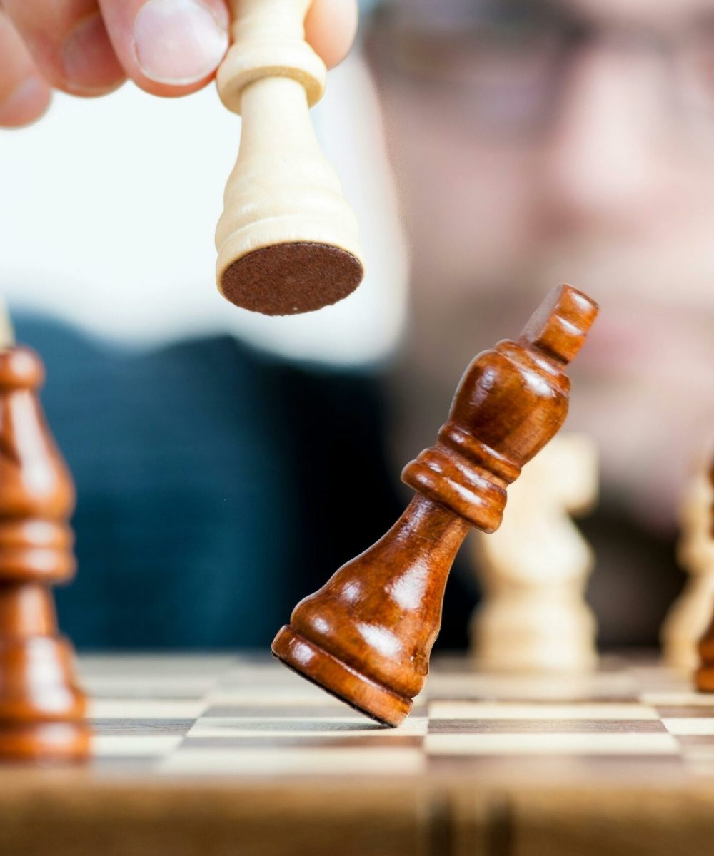 Close-up of a chess game with a focused player, emphasizing strategy and competition.